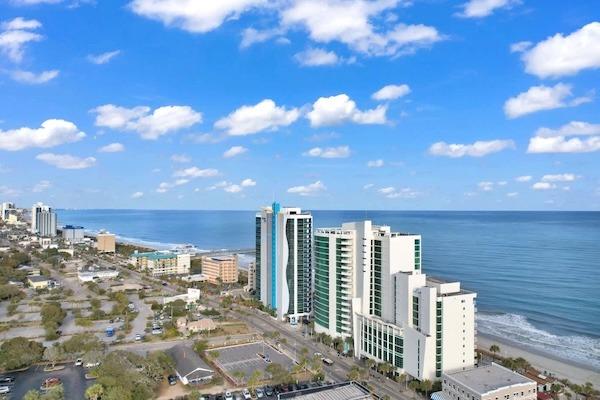 Aerial view of Sandy Beach Resort’s Palmetto Tower beside the beach and Atlantic Ocean in Myrtle Beach.